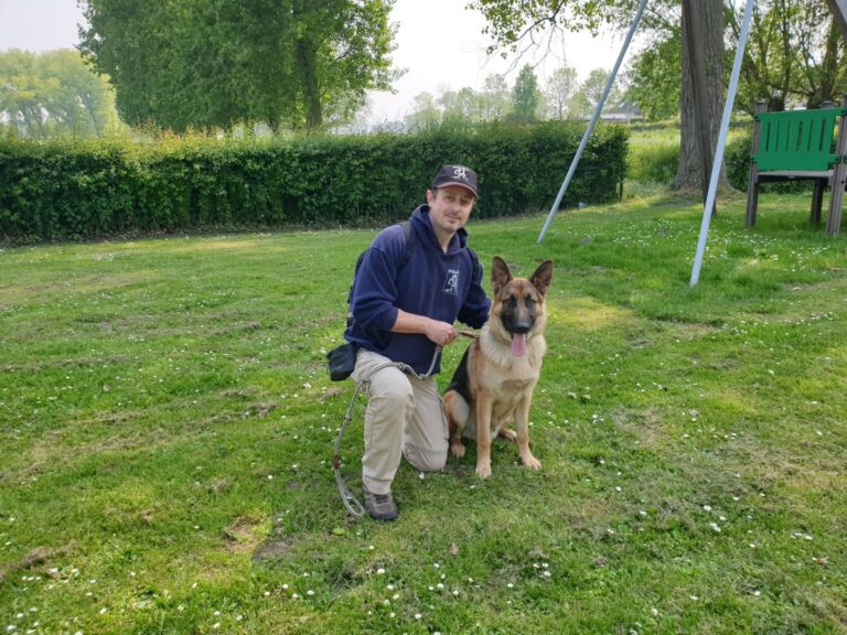 Spike de Duitse herder naast zijn baasje op het gras