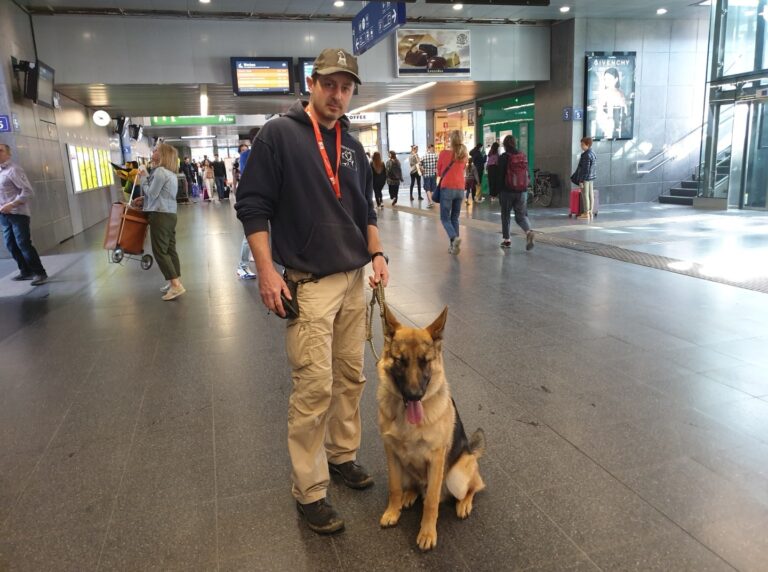 Spike de Duitse herder naast zijn baasje in de stationshal van Brugge